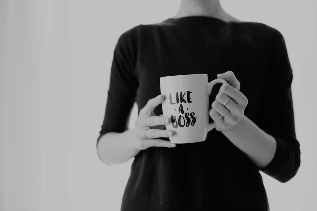 Black and white photo of a woman holding a cup that reads "Like a Boss"