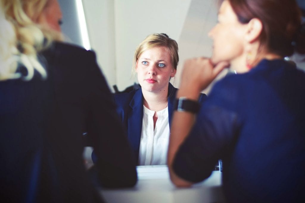three women around an interview table examine interview bias