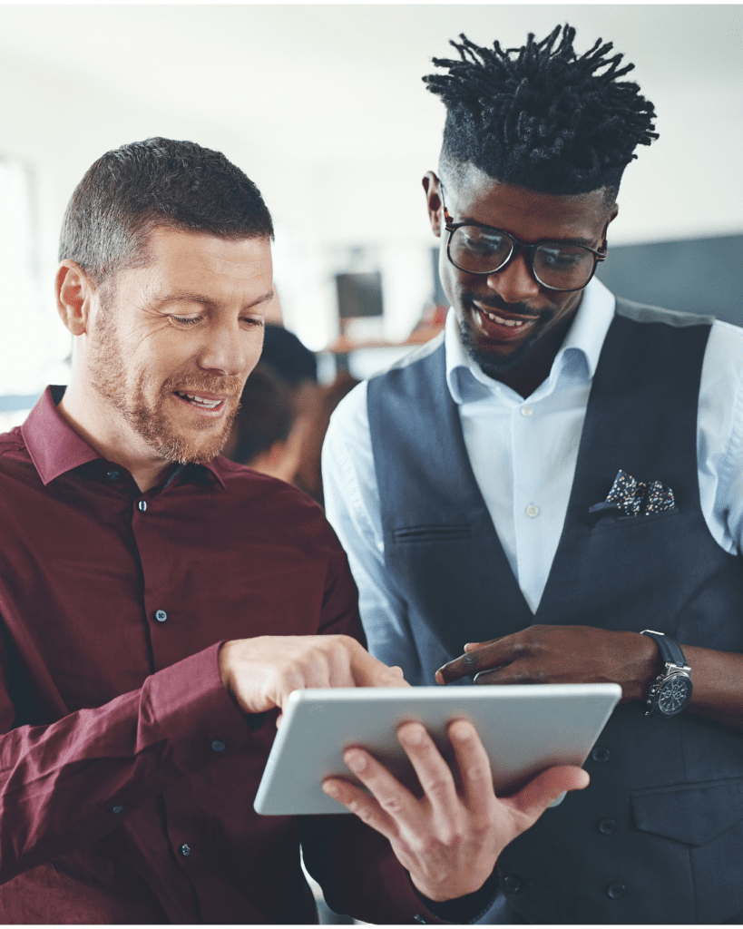 Two colleagues collaborating on a tablet, discussing projects in a modern office setting.